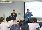 韓国・新羅大学からの訪問学生グループに語りかける学長（右）とリーダーの崔（チェ）教授